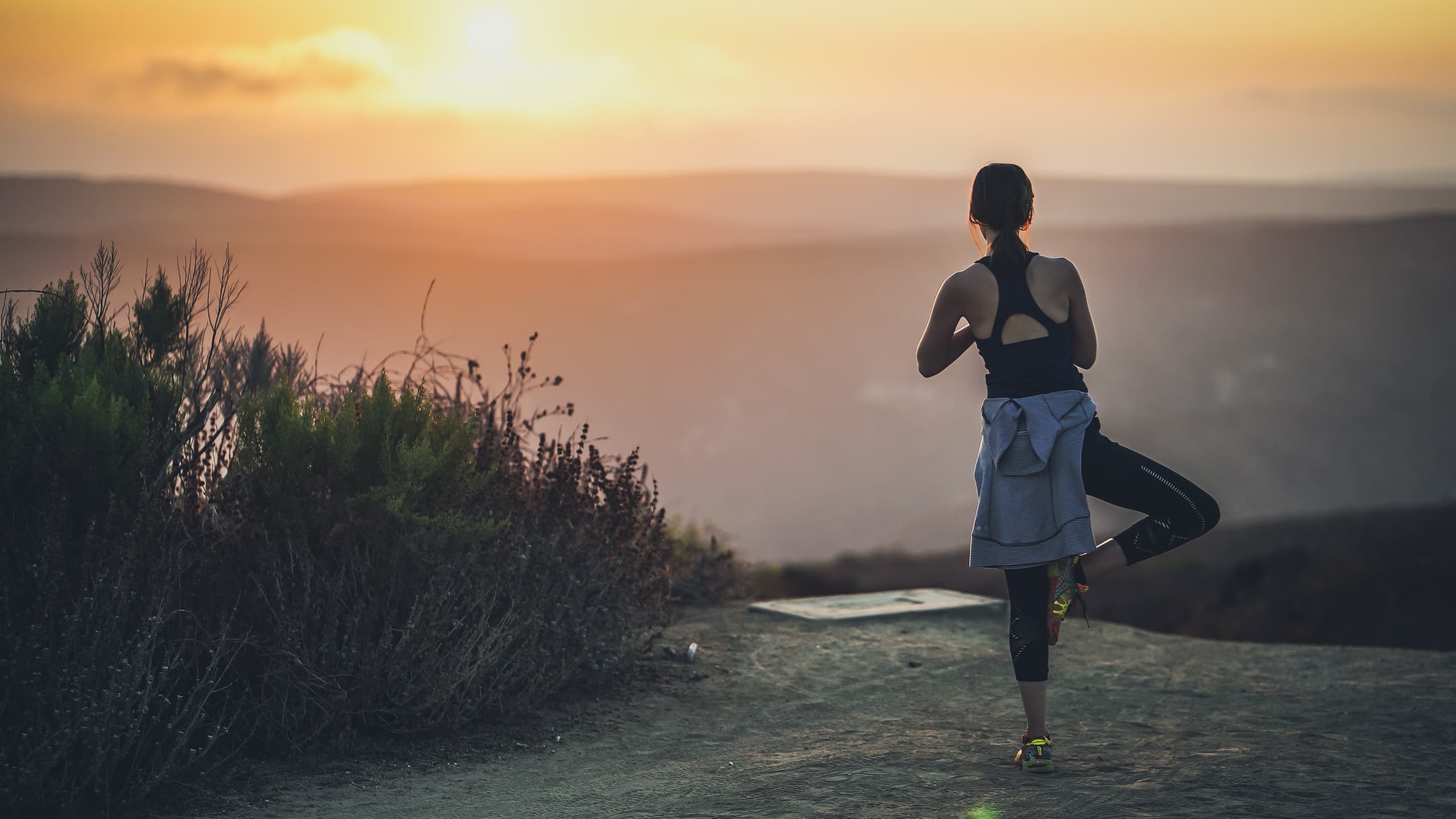 Woman doing yoga on mountaintop