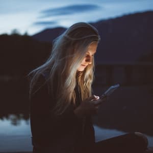 Woman staring at screen near lake