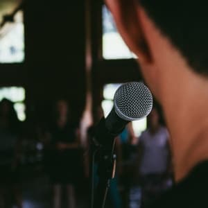 Man speaking to crowd with microphone