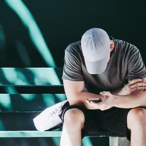 Man staring at phone while on bench